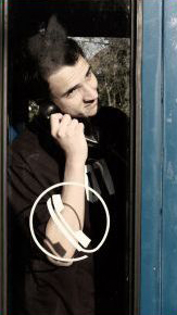 Chico en cabina de telefono